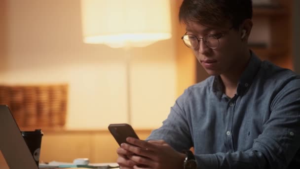 Die Seitenansicht Eines Asiatischen Mannes Der Nachtbüro Etwas Telefon Durchblättert — Stockvideo