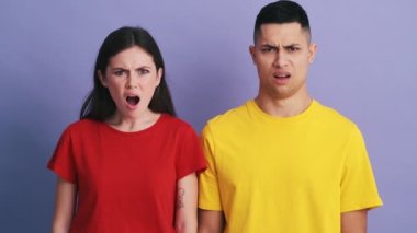 Mor stüdyoda dikilirken birbirlerine kötü gözle bakan ve başlarını sallayan nahoş bir sürpriz çift.