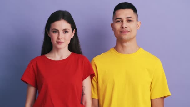 Casal Sorrindo Acenando Para Câmera Enquanto Estava Estúdio Roxo — Vídeo de Stock