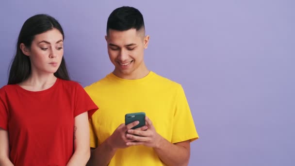 Dure Vrouw Gluurt Naar Telefoon Van Haar Vriend Terwijl Paarse — Stockvideo