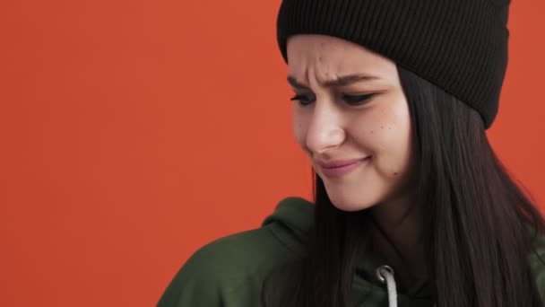 Kapüşonlu Hoşnutsuz Bir Kadın Stüdyonun Kırmızı Duvarında Tek Başına Dikiliyor — Stok video