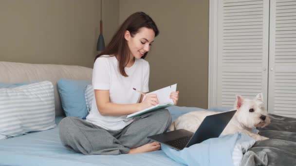 Pleased Woman Making Notes Using Her Laptop While Sitting Bedroom — ストック動画