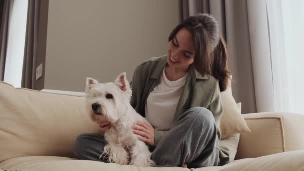 Ein Schönes Mädchen Streichelt Ihren Hund Während Sie Hause Sitzt — Stockvideo