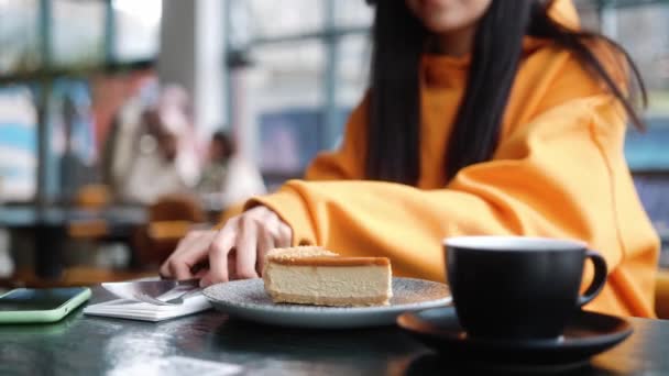 这张特写照片是一个女人坐在咖啡店里切的盘子上的一块蛋糕 — 图库视频影像