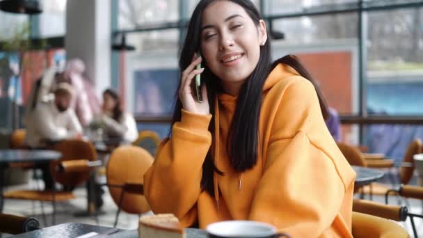 Die Fröhliche Frau Orangefarbenen Kapuzenpulli Telefoniert Während Sie Einem Café — Stockvideo