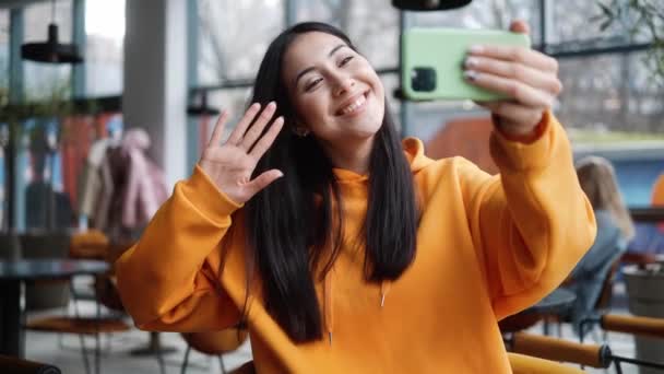 Mujer Sonriente Una Sudadera Con Capucha Naranja Tomando Una Selfie — Vídeo de stock