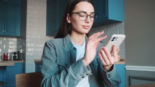 Die Selbstbewusste Frau Mit Brille Blättert Telefon Durch Etwas Während — Stockvideo