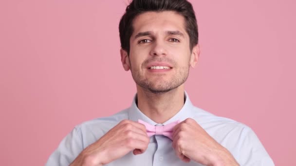 Seorang Pemuda Yang Positif Memperbaiki Dasi Kupu Kupunya Berdiri Terisolasi — Stok Video