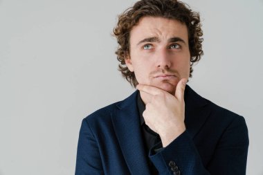 Gözlüklü düşünceli yakışıklı adam beyaz arka planda izole bir şekilde düşünüyor ve yukarı bakıyor.