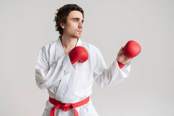 白い背景に隔離されたボクシングの手袋と空手を練習着物の若いスポーツマン — ストック写真