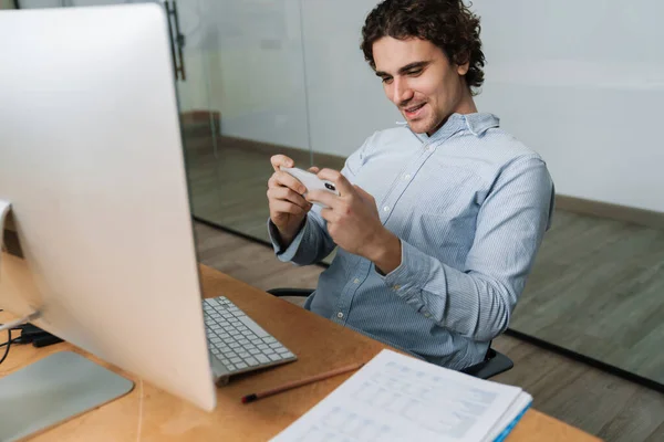 Boldog Fiatal Üzletember Ingben Használja Mobiltelefon Miközben Dolgozik Számítógép Irodában — Stock Fotó
