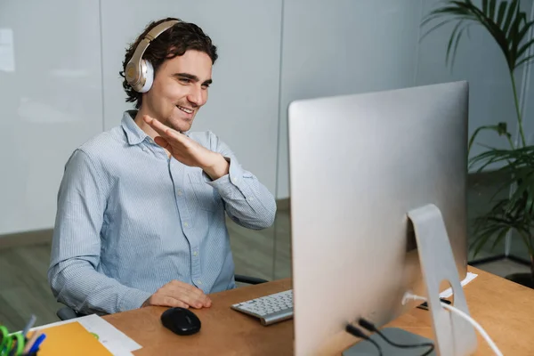 Καυκάσιος Νεαρός Χαρούμενος Επιχειρηματίας Ακουστικά Χαμογελώντας Ενώ Εργάζεται Στον Υπολογιστή — Φωτογραφία Αρχείου