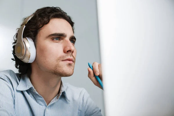 Καυκάσιος Νεαρός Σοβαρός Επιχειρηματίας Ακουστικά Που Εργάζεται Υπολογιστή Στο Γραφείο — Φωτογραφία Αρχείου