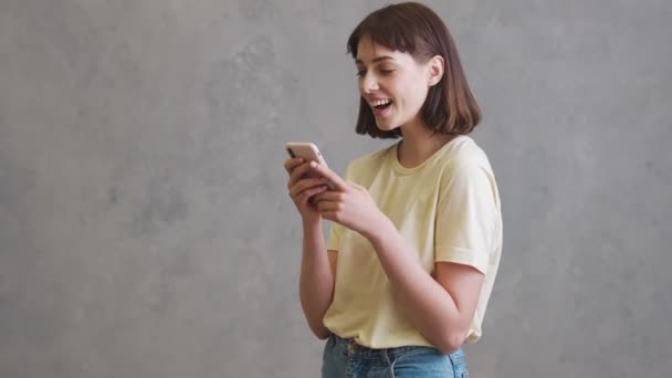 Chica Riendo Con Pelo Corto Volteando Través Cinta Teléfono Mientras — Vídeos de Stock