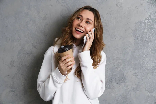 Jovem Alegre Usando Telefone Celular Enquanto Está Com Uma Xícara — Fotografia de Stock