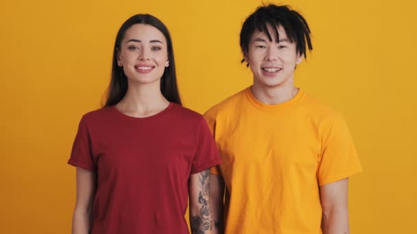 Überraschtes Multinationales Ehepaar Blickt Isoliert Über Gelber Wand Studio Die — Stockvideo
