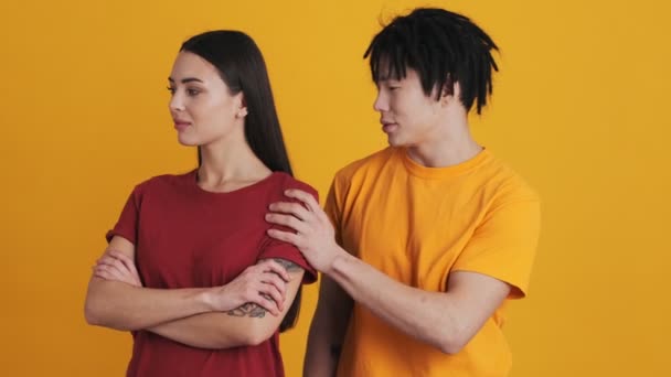 Een Multinationaal Echtpaar Staat Geïsoleerd Boven Een Gele Muur Studio — Stockvideo