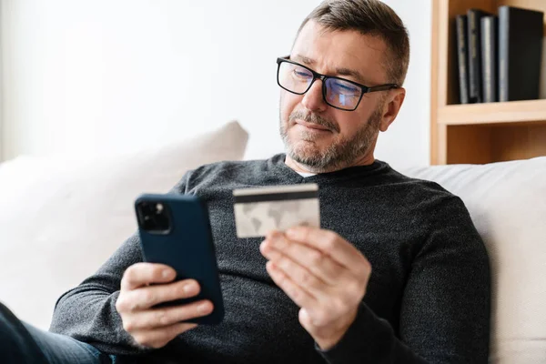 Gefallen Erwachsener Unrasierter Mann Mit Brille Und Handy Und Kreditkarte — Stockfoto
