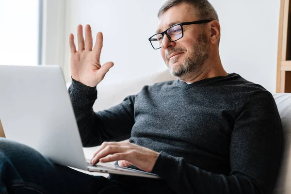 Zufriedener Erwachsener Unrasierter Mann Winkt Mit Der Hand Während Hause — Stockfoto