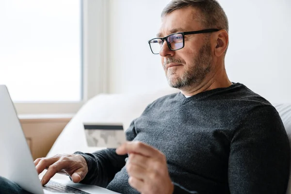 Ernsthafter Erwachsener Unrasierter Mann Benutzt Kreditkarte Während Hause Mit Laptop — Stockfoto