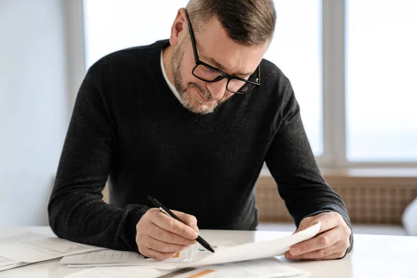 Lächelnder Erwachsener Unrasierter Mann Der Mit Papieren Tisch Haus Arbeitet — Stockfoto