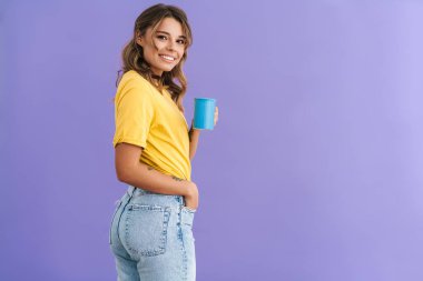 Mor arka planda izole edilmiş kahve içerken gülümseyen güzel güzel kız.