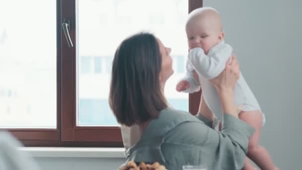Mutfakta Otururken Bebeğini Kucağına Alan Bir Annenin Yan Görüntüsü — Stok video