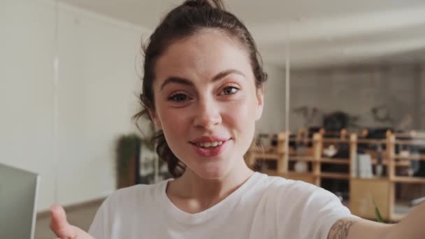 Χαμογελαστή Γυναίκα Μπλουζάκι Μιλάει Στην Κάμερα Και Κουνάει Χέρι Ενώ — Αρχείο Βίντεο