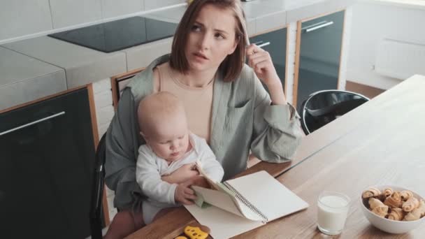 Uma Mãe Pensativa Segurando Seus Braços Seu Filho Lançando Páginas — Vídeo de Stock