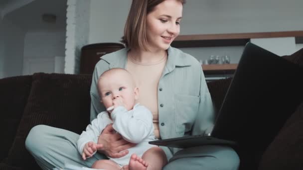 Uma Mãe Positiva Escrevendo Algo Laptop Segurando Seu Bebê Chupando — Vídeo de Stock