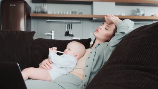 Uma Mãe Triste Deitada Sofá Segurando Cabeça Segurando Uma Criança — Vídeo de Stock