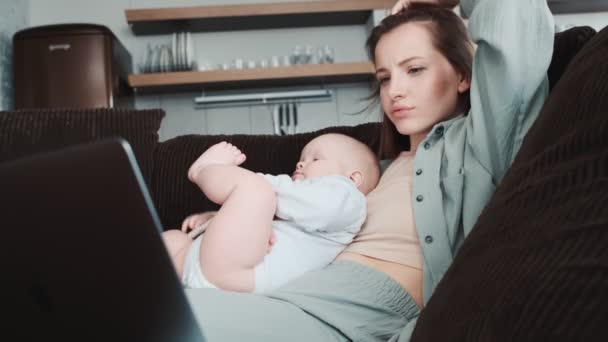 Zdenerwowana Mama Patrząca Laptopa Trzymająca Małe Dziecko Długopisem Rękach Siedząc — Wideo stockowe