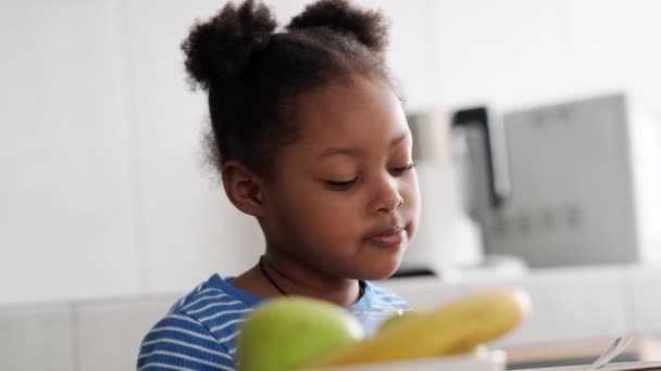 Ein Kleines Afrikanisches Mädchen Trinkt Saft Und Redet Beim Frühstück — Stockvideo