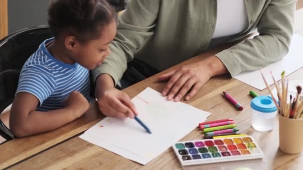 Afrikalı Bir Annenin Bir Kağıt Parçasına Çizdiği Kızının Yanında Oturduğu — Stok video
