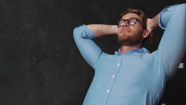 Homem Feliz Uma Camisa Azul Inclinando Para Trás Com Braços — Vídeo de Stock