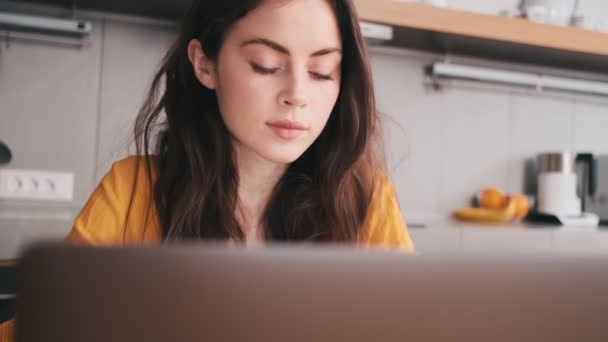 Una Donna Concentrata Che Guarda Computer Portatile Mentre Seduta Cucina — Video Stock