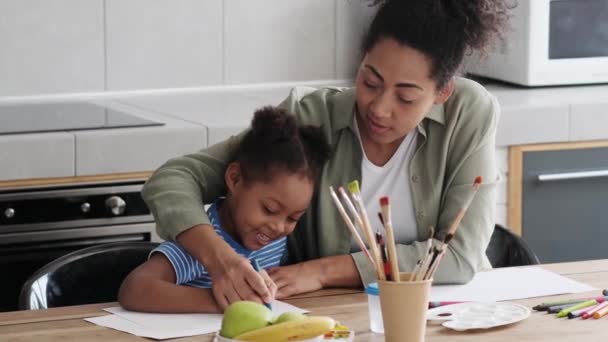 Una Niña Africana Sonriente Mamá Ayudándola Dibujar Con Marcador Papel — Vídeo de stock