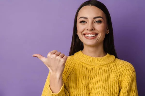 Щаслива Гарна Дівчина Посміхається Вказуючи Пальцем Убік Ізольовано Фіолетовому Фоні — стокове фото