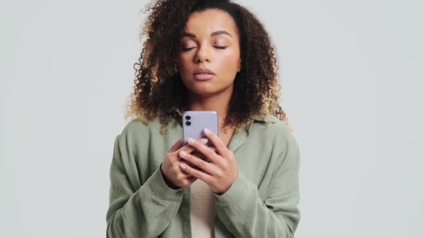 Una Afroamericana Disgustada Con Rizos Afro Sostiene Smartphone Aislado Sobre — Vídeos de Stock