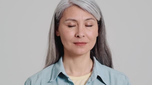Spokojna Starsza Kobieta Otwiera Oczy Patrzy Kamerę Stojącą Samotnie Nad — Wideo stockowe