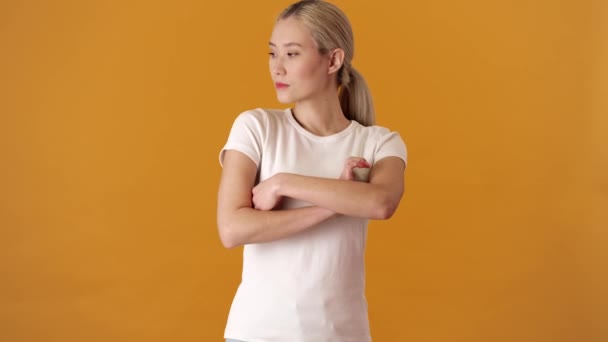 Uma Mulher Asiática Loira Ofendida Uma Camiseta Com Braços Cruzados — Vídeo de Stock