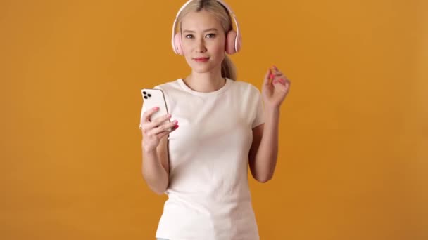 Pozytywna Blondynka Azjatka Shircie Tańczy Słucha Muzyki Słuchawkach Trzymając Telefon — Wideo stockowe