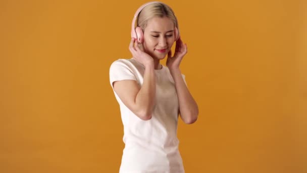 Smilende Blond Asiatisk Kvinne Skjorte Som Danser Hører Musikk Hodetelefoner – stockvideo