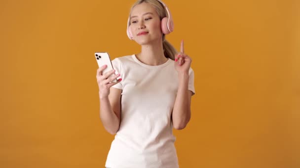 Smilende Blond Asiatisk Kvinne Skjorte Som Danser Hodetelefoner Til Musikken – stockvideo