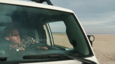 Yakışıklı bir adam göle vardıktan sonra cipten iniyor.