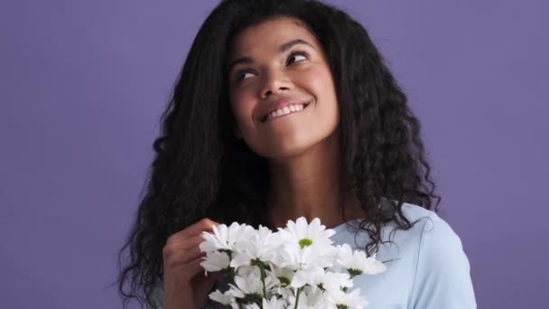 Uśmiechnięta Afrykanka Shircie Ciesząca Się Kwiatami Stojąc Fioletowym Studio — Wideo stockowe