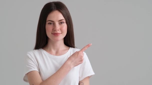 Een Vrolijke Vrouw Met Basic Shirt Wijst Naar Zijkant Geïsoleerd — Stockvideo