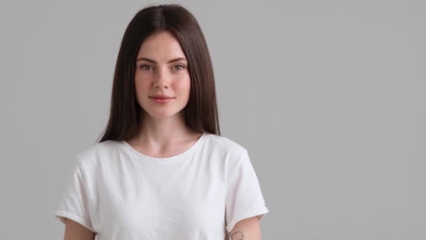 Una Mujer Sonriente Que Lleva Una Camiseta Básica Señala Lado — Vídeos de Stock