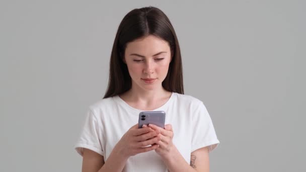 Uma Mulher Feliz Vestindo Camiseta Básica Está Usando Seu Smartphone — Vídeo de Stock