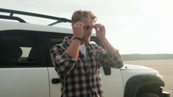 Homem Bonito Está Colocando Óculos Sol Sobre Natureza — Vídeo de Stock